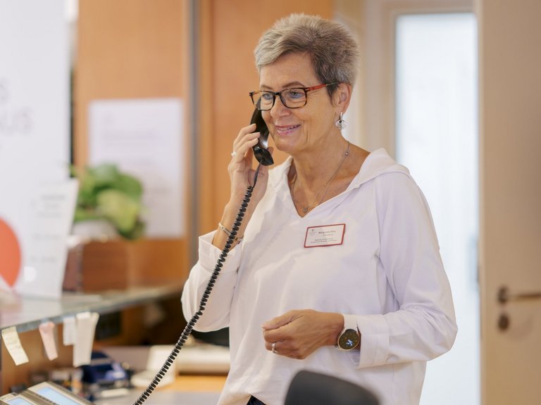 eine frau mit Brille telefoniert gerade 