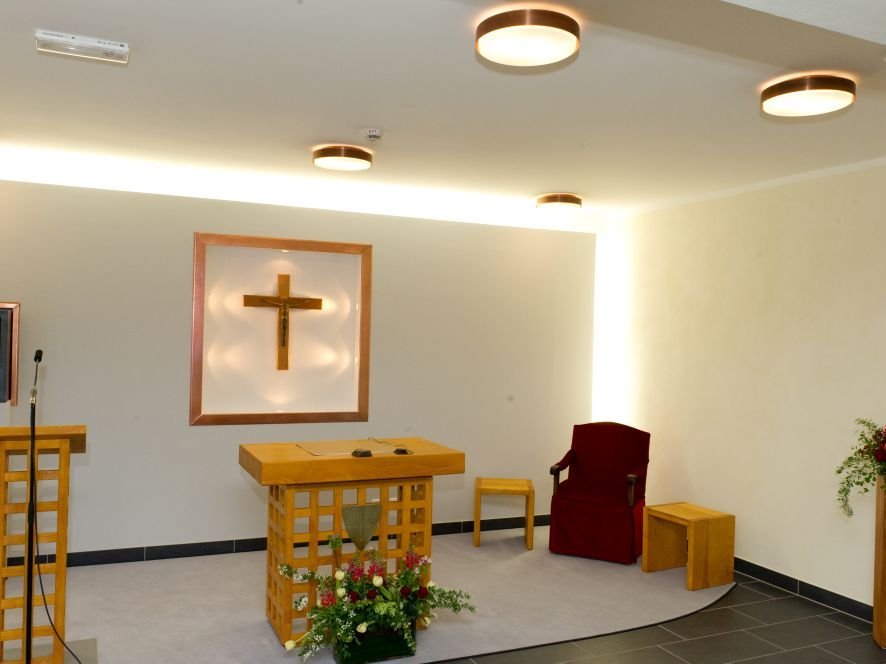 Ein Altar mit dem Jesuskreuz als zentralem Element, stimmungsvoll beleuchtet.