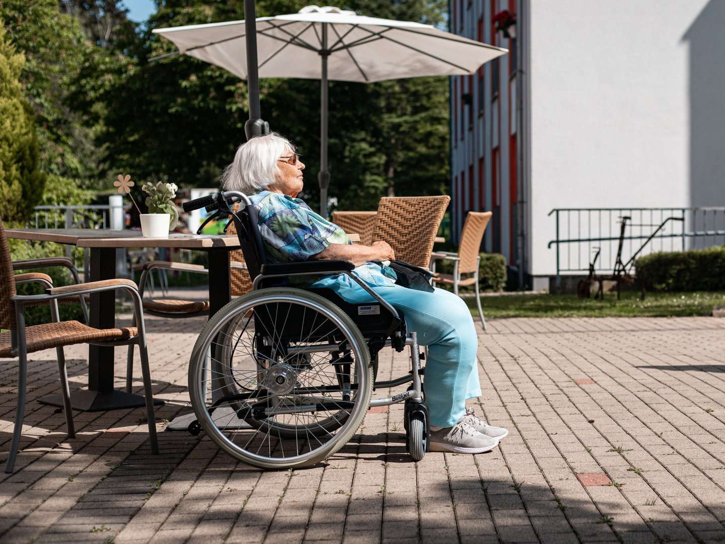 Eine Seniorin geniesst die Sonne im Rollstuhl